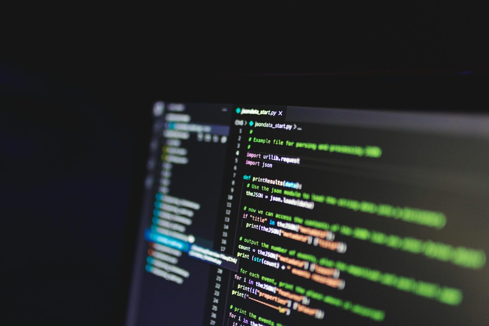 Programming code on a computer screen in a dark room, showcasing technology and IT expertise.